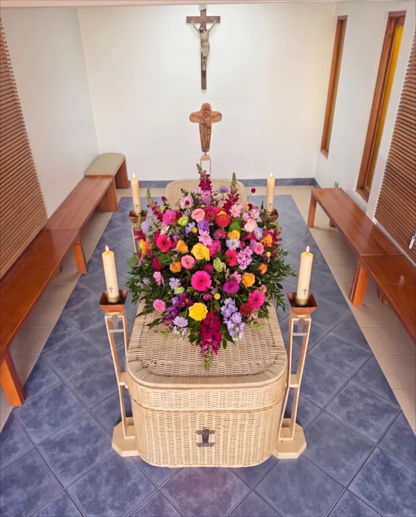 Urna Modelo Lincon Mimbre Natural con arreglo cubre urna, vista lateral - Funeraria María Ayuda